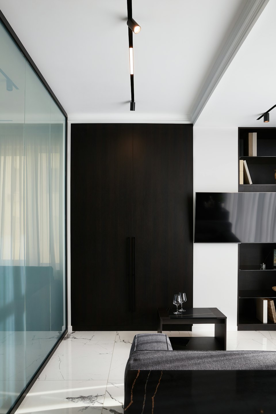 Soggiorno moderno con mobile in legno scuro e pavimento in marmo.